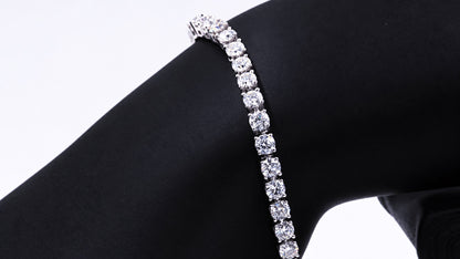 White gold moissanite tennis bracelet draped over a black display