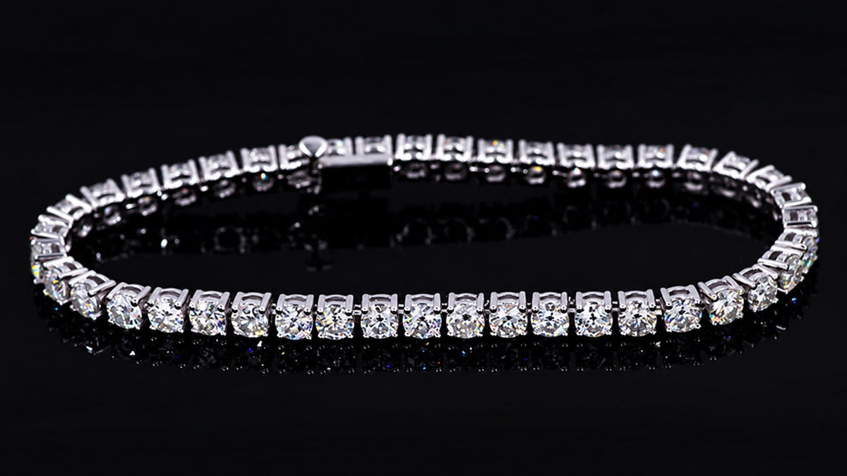 14K white gold moissanite tennis bracelet against black