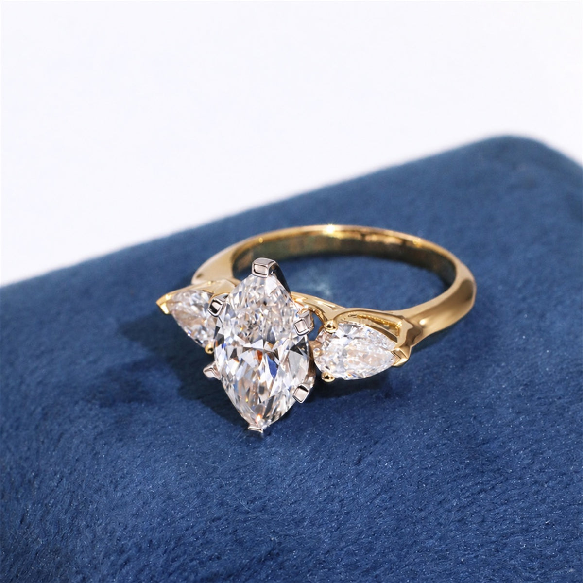 Three-stone lab diamond ring on dark blue fabric