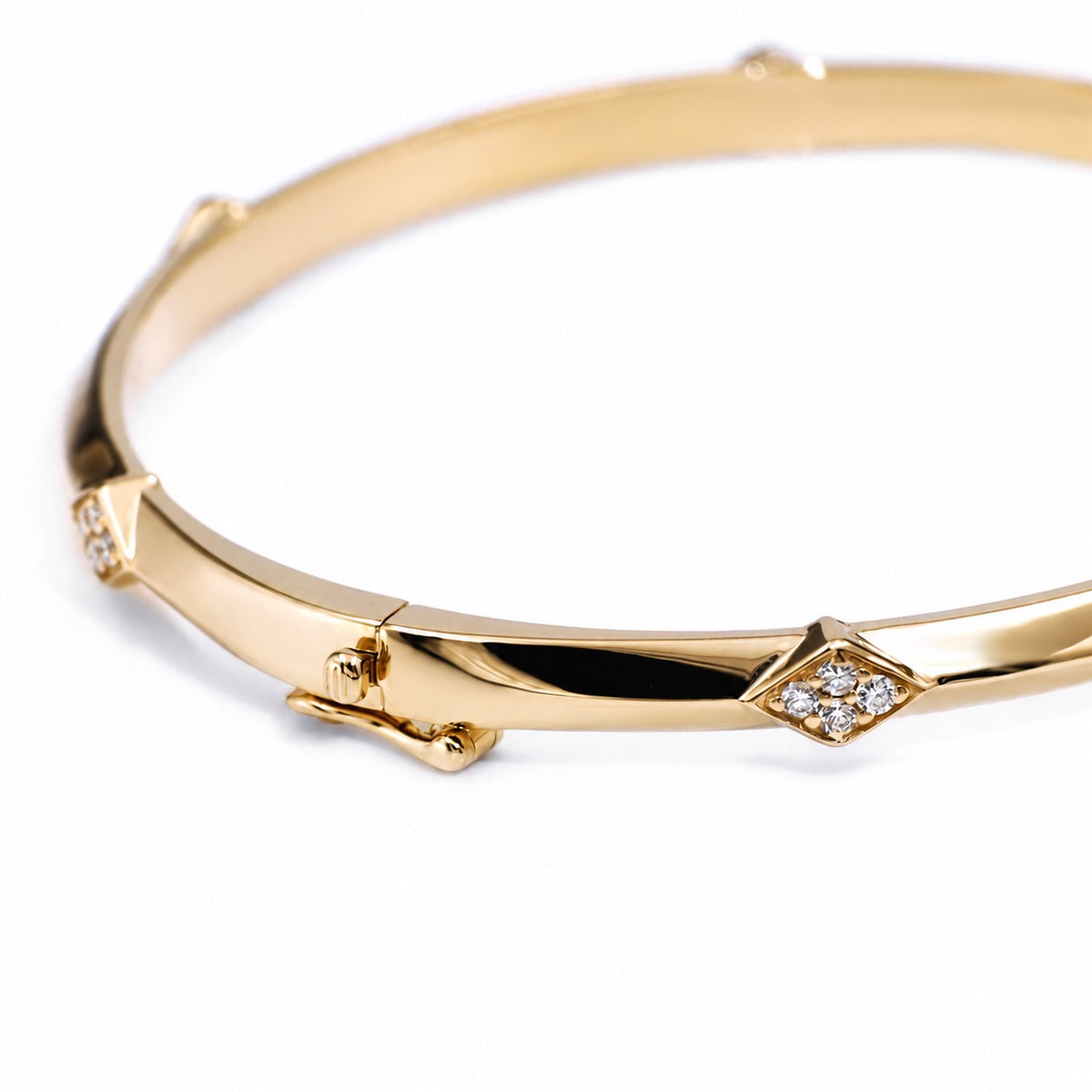 Close view of a lozenge-shaped lab diamond accent on the gold bangle