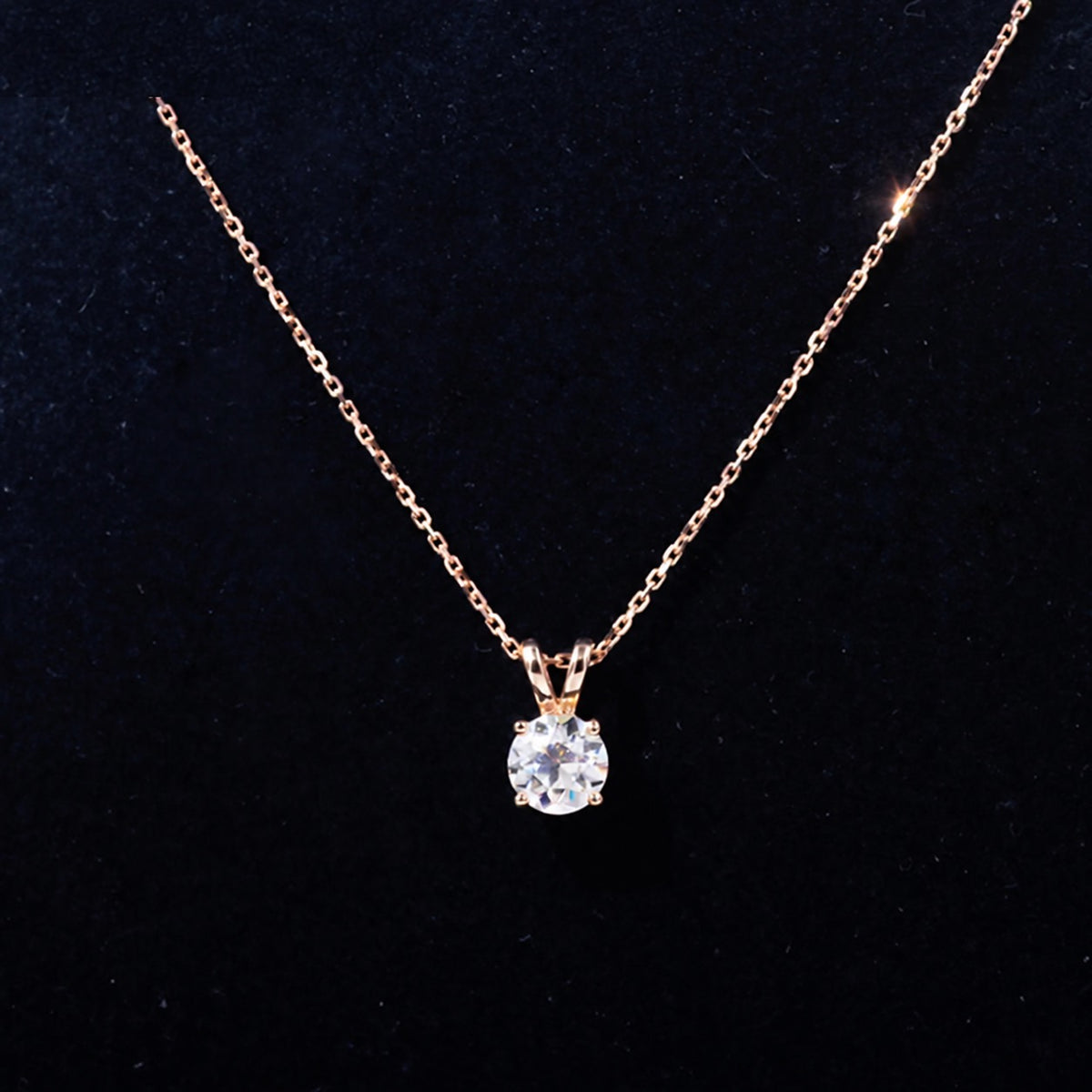 Rose gold moissanite pendant displayed on a black necklace bust